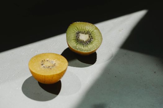 在明亮的阳光下，切片的奇异果投下阴影，体现了健康新鲜的食品理念