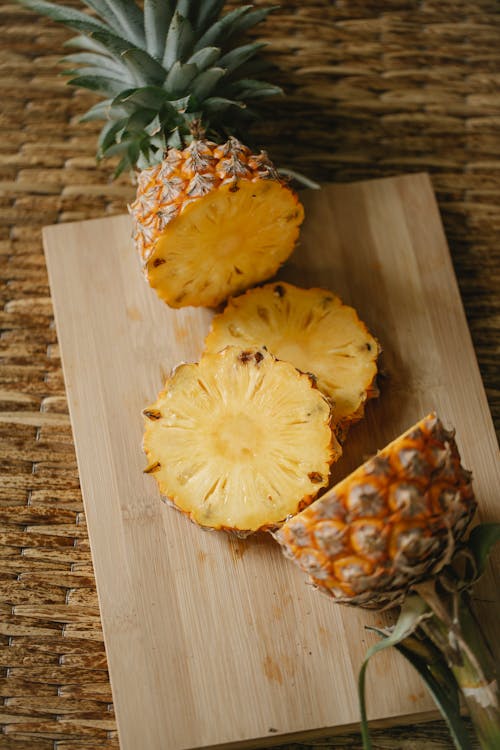 Sliced pineapple on wooden board