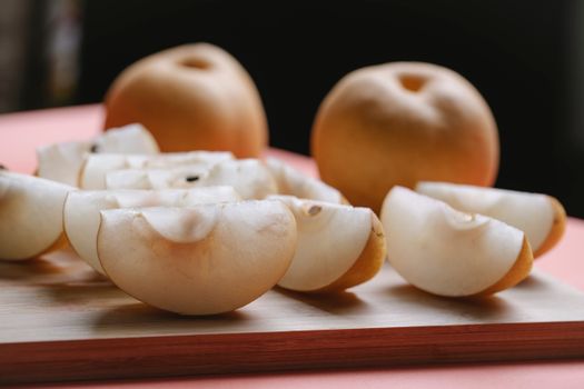 Slices of Asian pear on wooden board