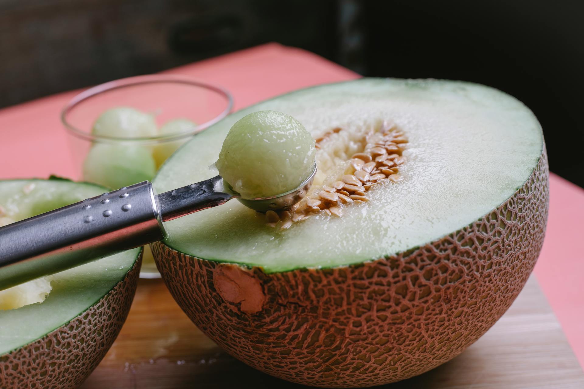 Halved melon with scoop in kitchen