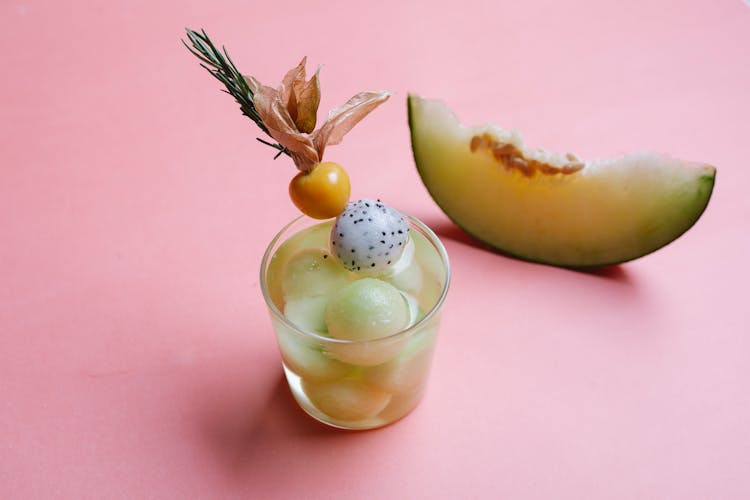 Glass Of Melon Cocktail On Pink Background