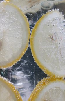 特写镜头中，柠檬片浸入起泡水