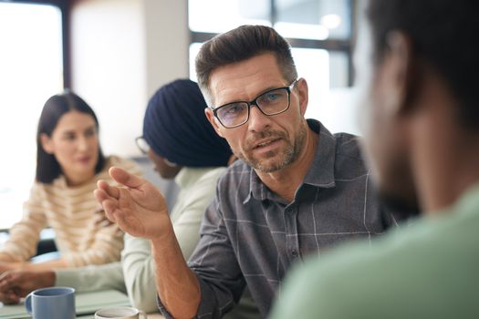 A diverse group having a focused discussion in a modern office setting.