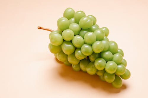 Fresh ripe green grapes on beige background