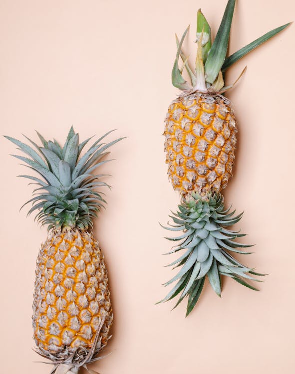 Fresh pineapples on beige background