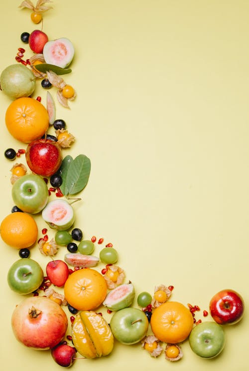 From above of different delicious ripe fresh juicy fruits and berries on beige background