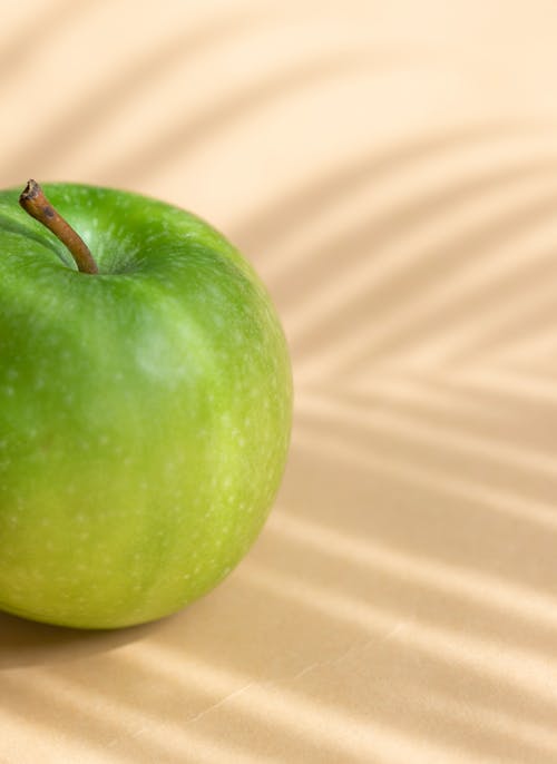 Fresh ripe green apple placed on white surface