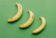 Ripe bananas on green surface