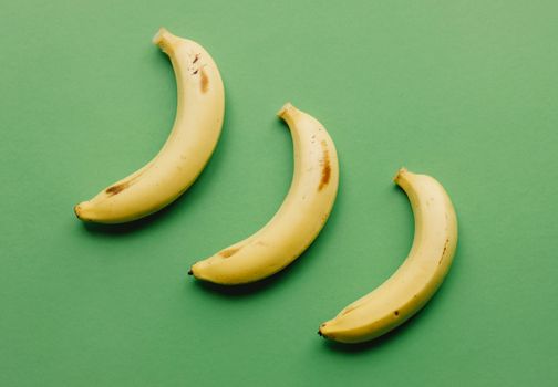 Ripe bananas on green surface