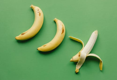 Ripe bananas on green surface