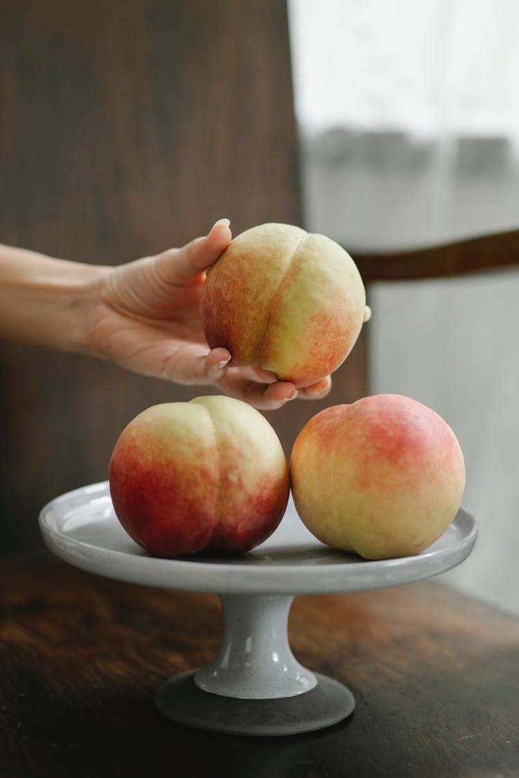 Fresh Sweet Peaches On White Stand In Kitchen