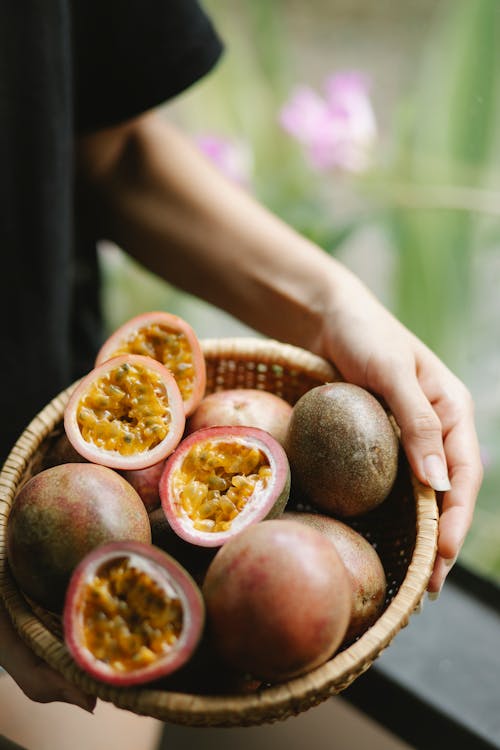 Woman with fresh passion fruit in bowl