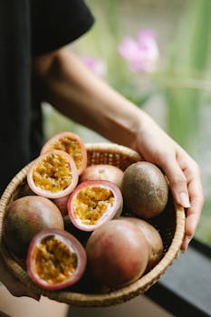 A wicker basket filled with ripe passion fruits held outdoors, showcasing fresh tropical flavor.