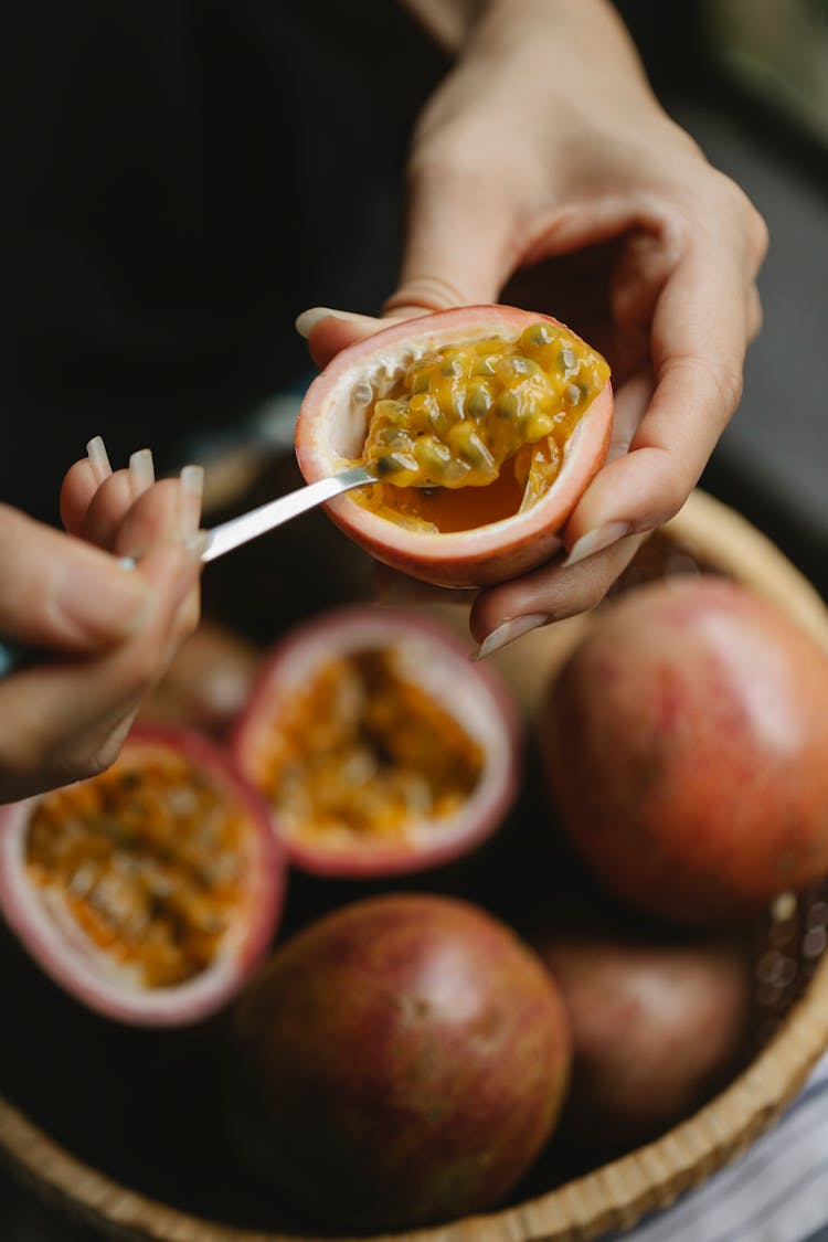 Female Enjoying Pulp Of Passion Fruit