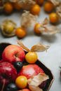 Delicious fruits in heaped in bowl and scattered on table