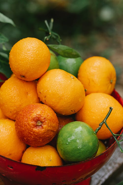 Fresh ripe oranges and limes in bowl