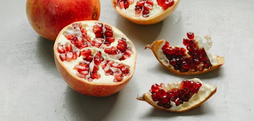 From above of fresh ripe red pomegranate placed on gray table in kitchen