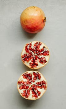 Top view of composition of ripe fresh red pomegranates arranged on gray background