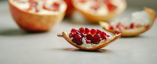 Free Slice of ripe pomegranate placed on table Stock Photo
