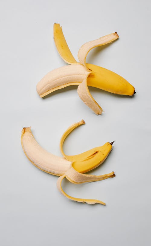 Top view of fresh ripe mellow yellow bananas with skin place on white background