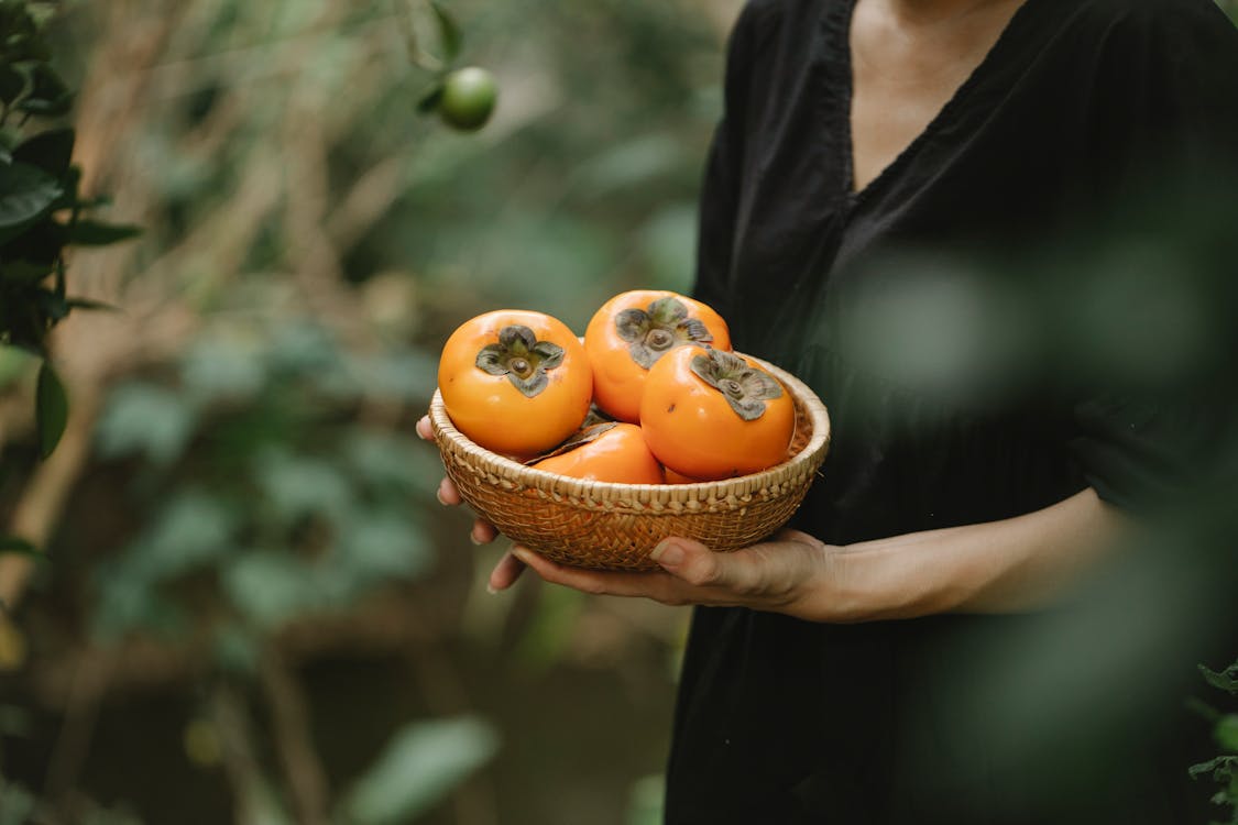 бесплатная Лицо, занимающее корзину апельсиновых фруктов Стоковое фото
