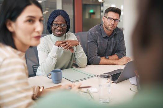 A diverse group of professionals engaging in a team meeting around a conference table.