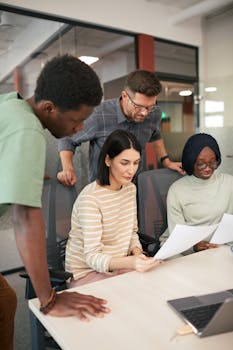 Group of diverse colleagues working together on a project in an office setting.