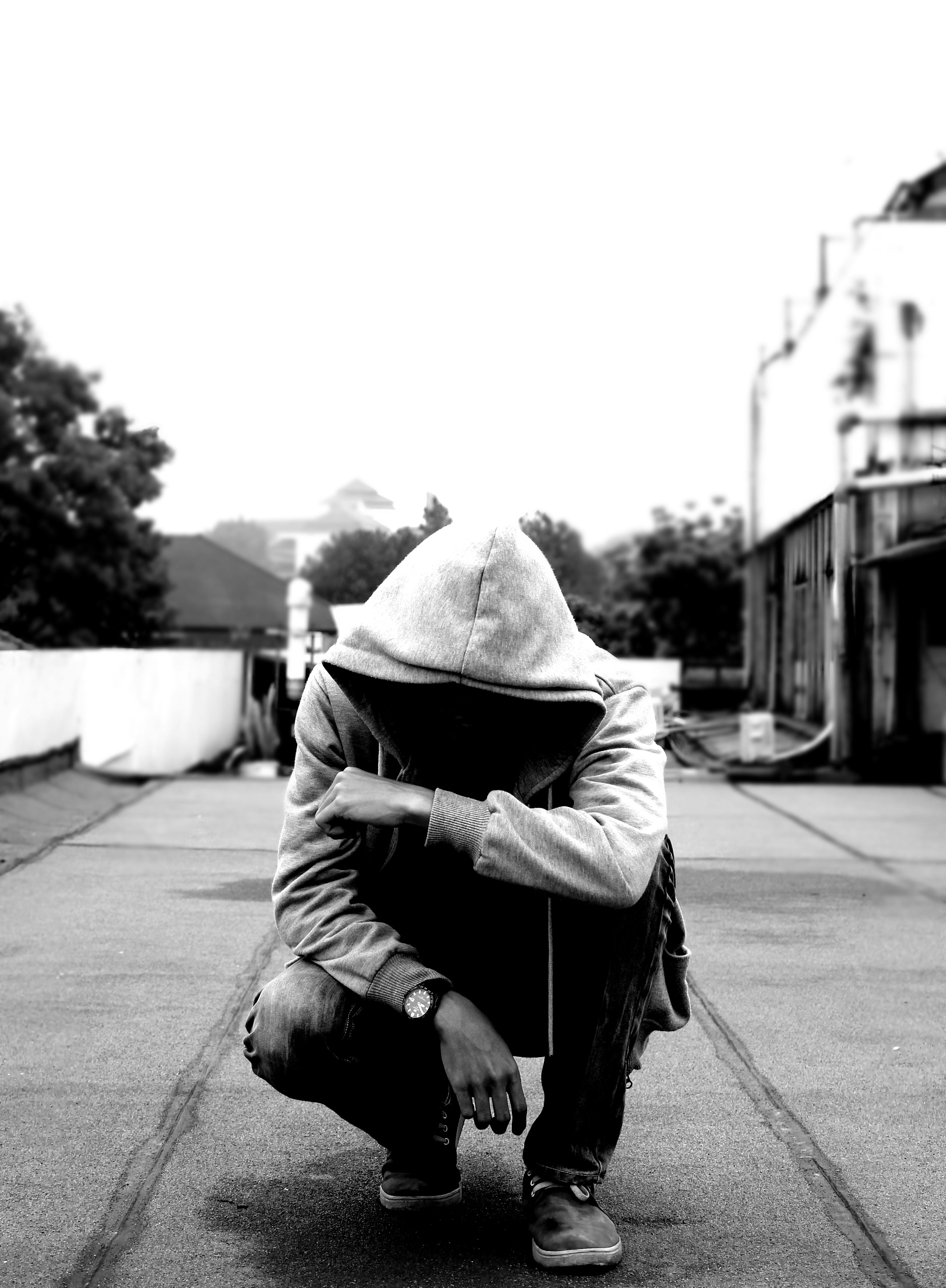 Person Wearing Black  Zip  Hoodie Sitting in Front of Gray 