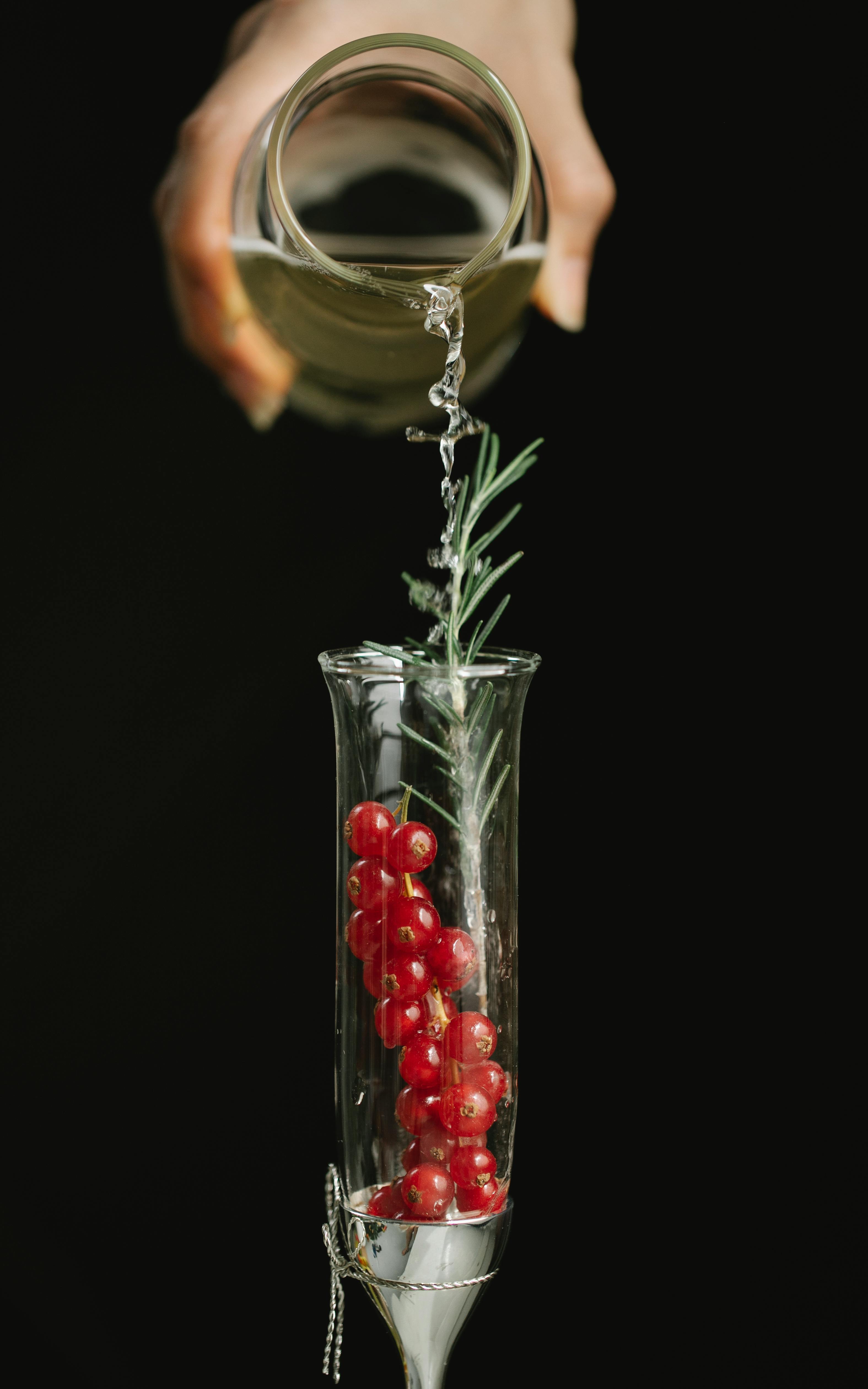 crop person adding drink in glass