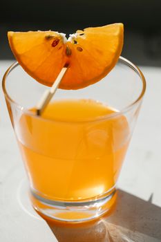 桌子上放着透明的玻璃杯，里面装着五颜六色的美味饮料和新鲜多汁的橙片