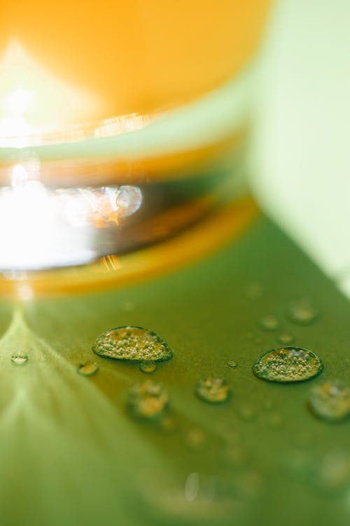 Green table with drops and glass of juice