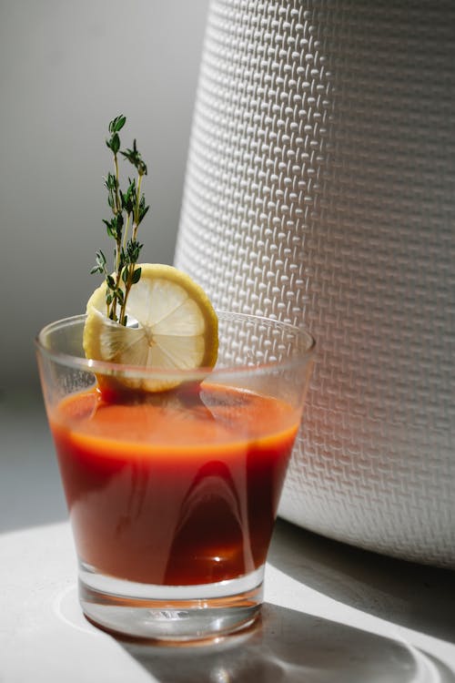 Glass of alcoholic cocktail with tomato juice and lemon