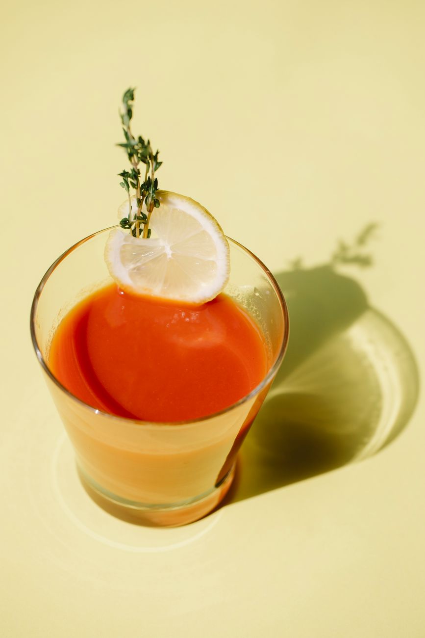 Buz dolu kadeh içinde domates renginde Bloody Mary, yanında kereviz sapı, limon dilimi ve yeşil zeytin.