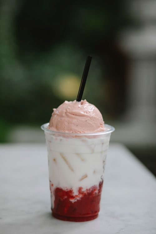 Free Plastic glass of yummy milkshake with ice cream and strawberry puree on table in cafe Stock Photo