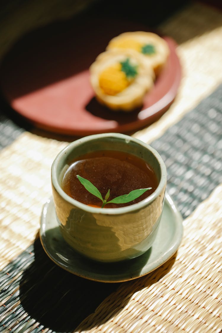 Cup Of Black Tea With Mint On Straw Mat