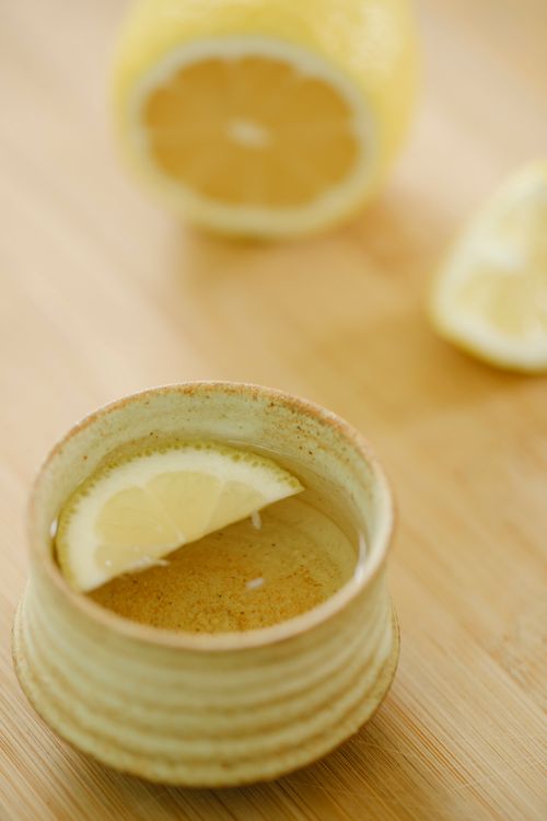 Free From above of oriental cup of green tea with aromatic juicy lemon slice on wooden table Stock Photo