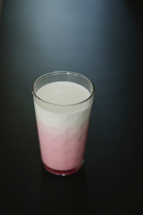 Free From above of transparent ornamental glass of tasty sweet protein milkshake on dark background Stock Photo