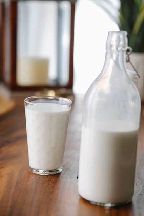Free Bottle and glass of milk on desk Stock Photo