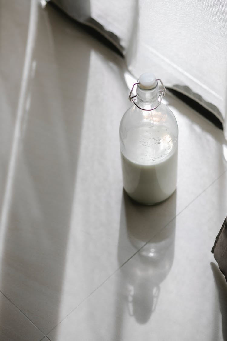 Milk In Glass Bottle On Table