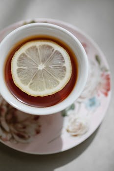 Closeup top view of hot fresh aromatic tea with lemon slice on saucer