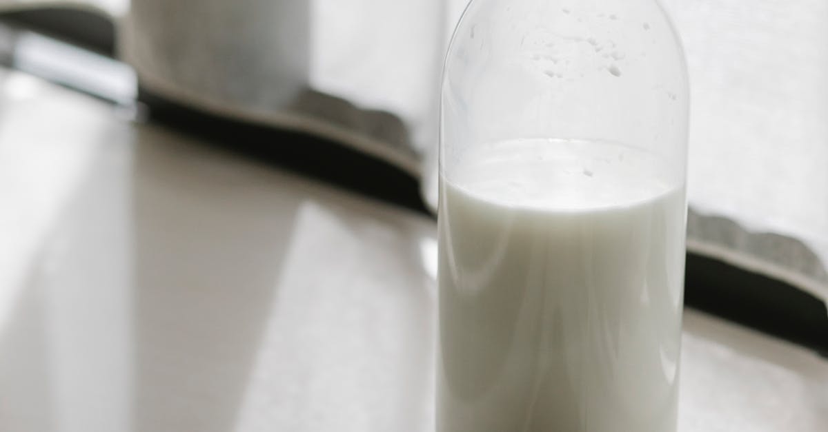 Glass bottle with milk on table