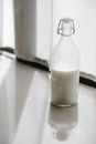 Glass bottle with milk on table