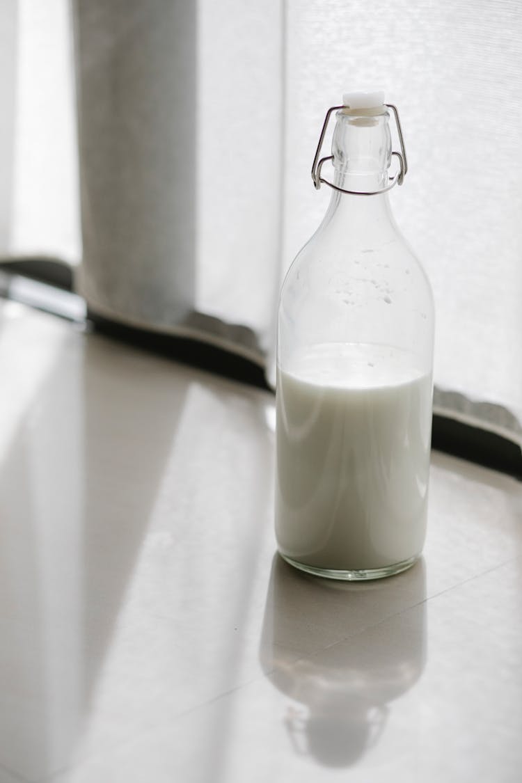 Glass Bottle With Milk On Table