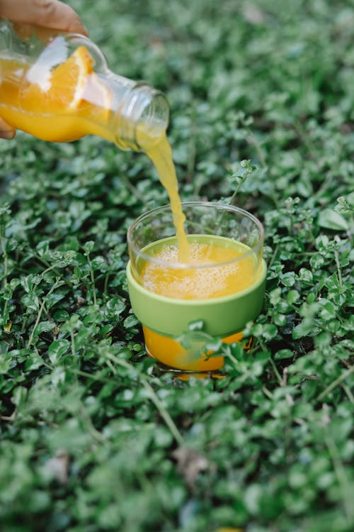 Free Crop person pouring orange juice Stock Photo