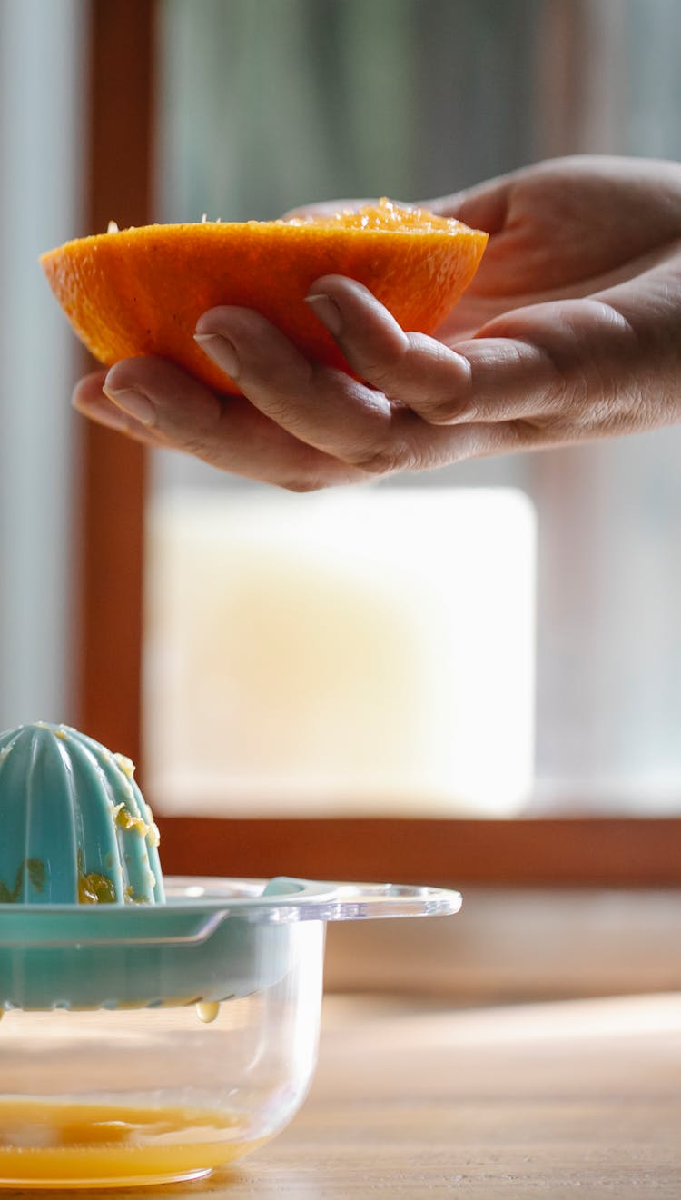 Crop Unrecognizable Person Squeezing Orange Juice In Kitchen