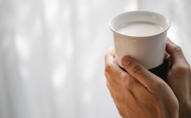 Crop Faceless Person Holding Cup Of Hot Milk