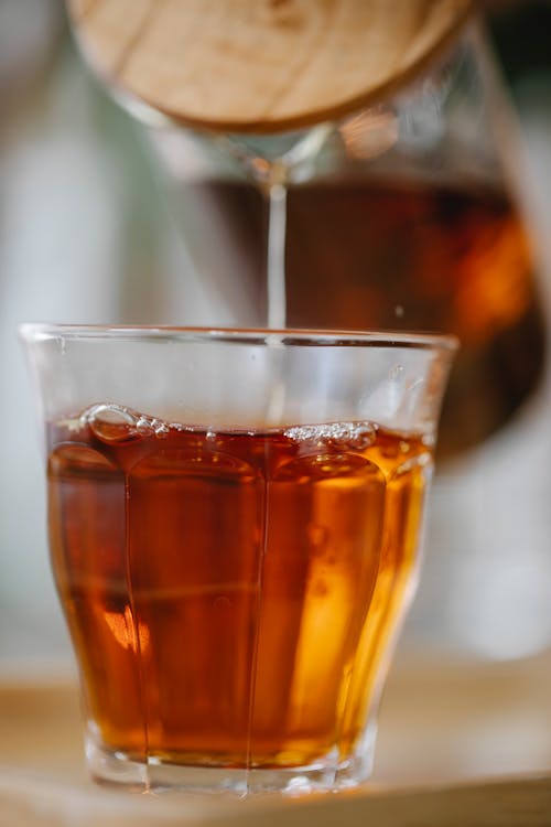 Herbal black tea pouring into glass