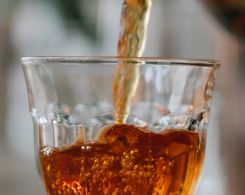Aromatic black tea pouring into glass