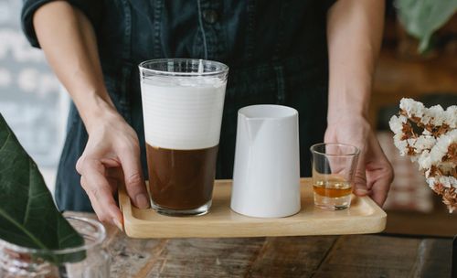 Free Crop unrecognizable female barista serving delicious fresh iced chocolate coffee on tray with shot of cognac Stock Photo