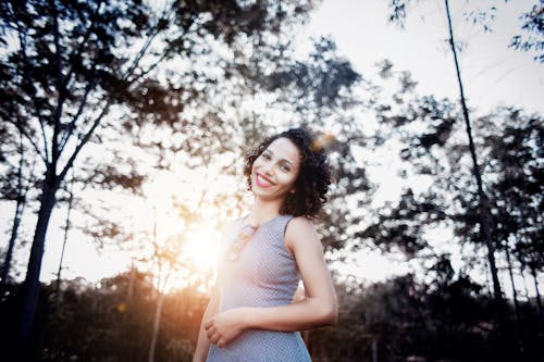 Free Woman Smiling Under Trees Stock Photo
